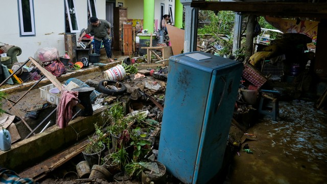 Warga membersihkan lumpur usai banjir di Kampung Tugu, Baros, Kota Sukabumi, Jawa Barat, Jumat (18/2/2022). Foto: Iman Firmansyah/Antara Foto