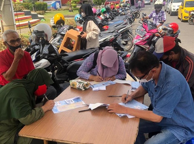Pengisian data diri oleh peserta perpanjangan SIM pada pelayanan perpanjangan SIM Keliling di Tugu Juang Kota Bandar Lampung. | Foto: Hadi/Lampung Geh