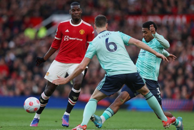 Pemain Manchester United Paul Pogba beraksi dengan pemain Leicester City Wesley Fofana dan Jonny Evans di Stadion Old Trafford, Manchester, Inggris, Sabtu (2/4/2022). Foto: Russell Cheyne/REUTERS