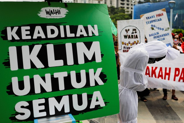 Poster bertuliskan 'Keadlian iklim untuk semua' dalam aksi protes perubahan iklim di Jakarta, Jumat (25/3/2022). Foto: Willy Kurniawan/REUTERS