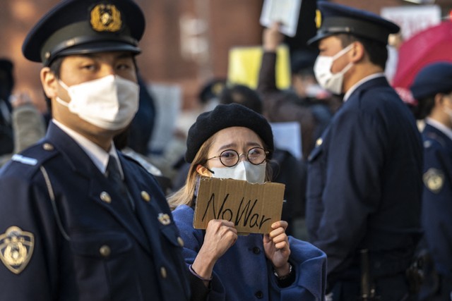 Aktivis memegang secarik tulisan ketika berkumpul di dekat kedutaan Rusia untuk memprotes invasi Rusia ke Ukraina, di Tokyo, Jumat (25/2/2022).
 Foto: Charly Triballeau/AFP