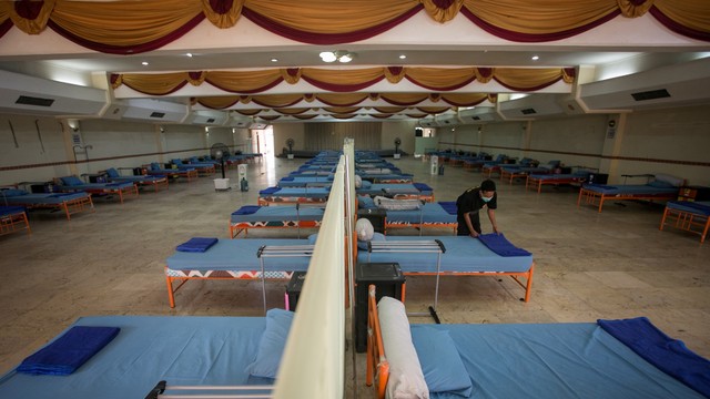 Relawan Satgas Penanganan COVID-19 Kota Solo menyiapkan almari dan kasur tempat tidur untuk isolasi terpusat pasien COVID-19 di Graha Wisata Niaga, Solo, Jawa Tengah, Kamis (17/2/2022). Foto: Mohammad Ayudha/Antara Foto