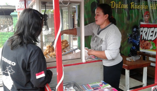 Sulasmi melayani konsumen yang membeli fried chicken di kedainya, Kamis (17/02/2022). (Foto: Peggy Kakisina)