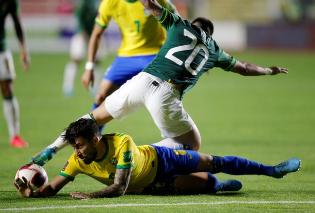 Pemain Brasil Alex Telles duel dengan pemain Bolivia Henry Vaca  saat kualifikasi Amerika Selatan di Estadio Hernando Siles, La Paz, Bolivia. Foto: Manuel Claure/Reuters