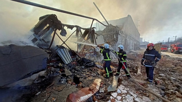 Tim penyelamat bekerja di lokasi gudang penyimpanan produk yang terbakar setelah penembakan, saat serangan Rusia di Ukraina berlanjut, di Kharkiv, Ukraina, Rabu (16/3/2022). Foto: Vitalii Hnidyi/REUTERS