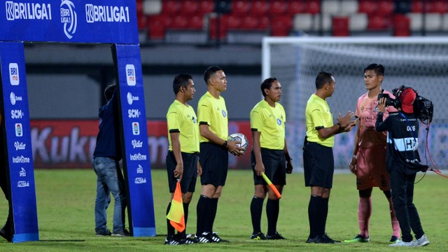 Kapten Madura United Fachruddin Wahyudi Aryanto berdiskusi dengan wasit saat pertandingan Liga 1 melawan Persipura Jayapura di Stadion Kapten I Wayan Dipta, Gianyar, Bali, Senin (21/2/2022). Foto: Fikri Yusuf/Antara Foto