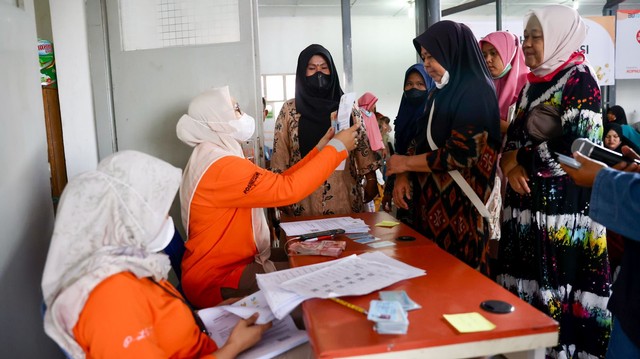 Petugas kantor pos melayani warga penerima BLT Minyak Goreng. Foto: Suparta/acehkini