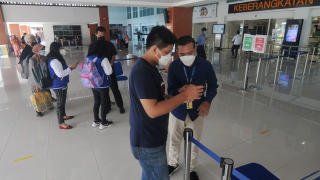 Petugas bandara mengecek dokumen e-HAC dan sertifikat Vaksin COVID-19 milik calon penumpang di Bandara Adi Soemarmo, Boyolali, Jawa Tengah, Rabu (9/3/2022). Foto: Adiwinata Solihin/ANTARA FOTO