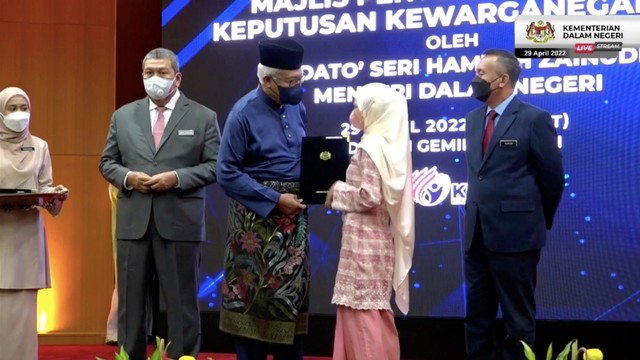 Rohana Abdullah (22) menerima surat kewarganegaraan Malaysia dari Mendagri Datuk Seri Hamzah Zainuddin. Foto: Facebook/hamzahzainudinofficial