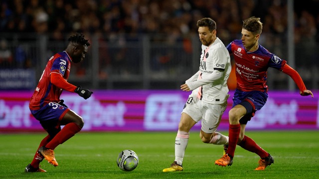 Pemain Paris St Germain Lionel Messi beraksi bersama pemain Clermont Yohann Magnin di Stade Gabriel Montpied, Clermont-Ferrand, Prancis, Sabtu (9/4/2022). Foto: Stephane Mahe/REUTERS