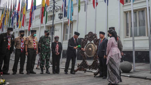 Dirjen Informasi dan Diplomasi Publik Kementerian Luar Negeri Teguh Wardoyo (tengah) memukul gong sebagai tanda pembukaan rangkaian peringatan 67 KAA saat upacara pengibaran bendera peserta di Jalan Sukarno, Bandung, Jawa Barat, Senin (18/4). Foto: Raisan Al Farisi/ANTARA FOTO