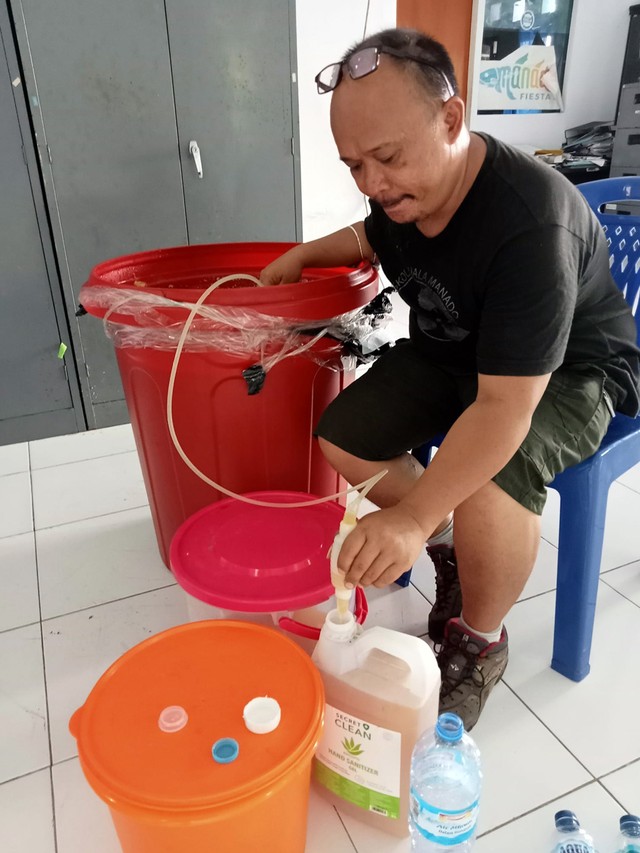 Denny Taroreh menunjukkan cara memanen Eco Enzym, cairan serbaguna organik, kepada TP PKK Kecamatan Tikala, Kota Manado. (foto: istimewa)