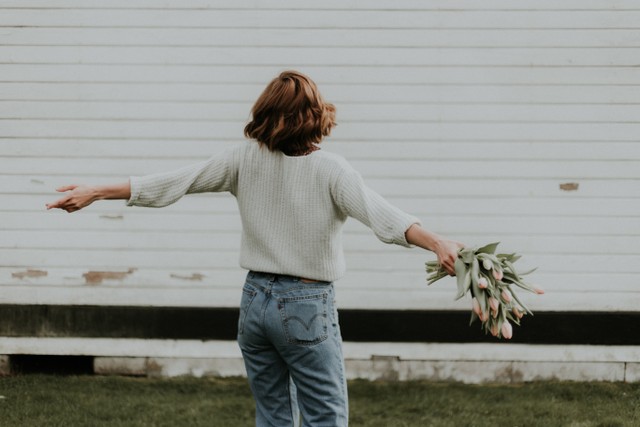 kata kata jomblo terhormat. sumber foto: unsplash/perempuan menggenggam bunga.