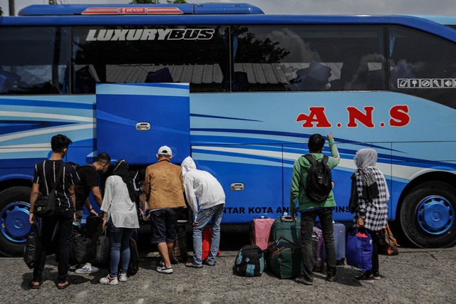Sejumlah calon penumpang memasukkan barang bawaanya ke dalam bagasi bus di Terminal Kalideres, Jakarta, Rabu (20/4/2022). Foto: Fauzan/ANTARA FOTO