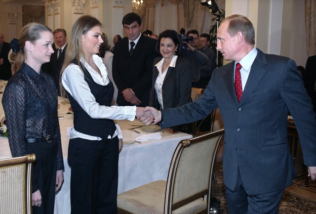 Presiden Rusia Vladimir Putin (kanan) berjabat tangan dengan pesenam terkenal Rusia Alina Kabayeva (tengah) dan Svetlana Khorkina (kiri). Foto: Sergei C / POOL / AFP