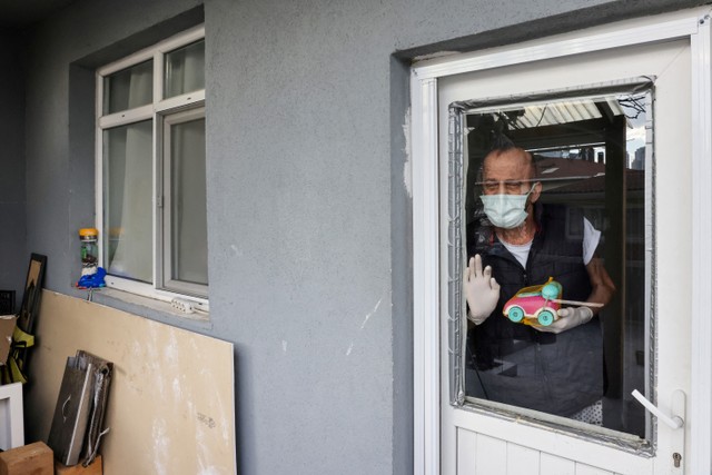 Muzaffer Kayasan menunggu kunjungan putranya Gokhan dan cucu perempuannya Azra di rumahnya di Istanbul, Turki, Kamis (10/2/2022). Foto: Umit Bektas/REUTERS