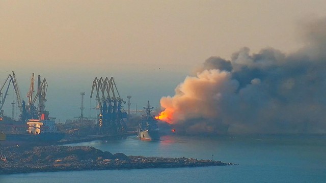 Asap mengepul dari kebakaran sebuah kapal Rusia, di pelabuhan Berdiansk, Ukraina, Kamis (24/3/2022). Foto: Kirillovka.ks.ua/Handout via REUTERS