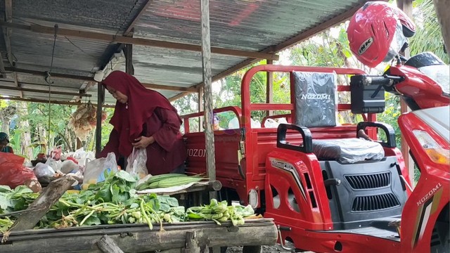 Nuraini Sulistyoningsih, pedagang sayur keliling dengan sepeda motor roda tiga yang baru dibelikan kedua anaknya. (foto: dok istimewa)