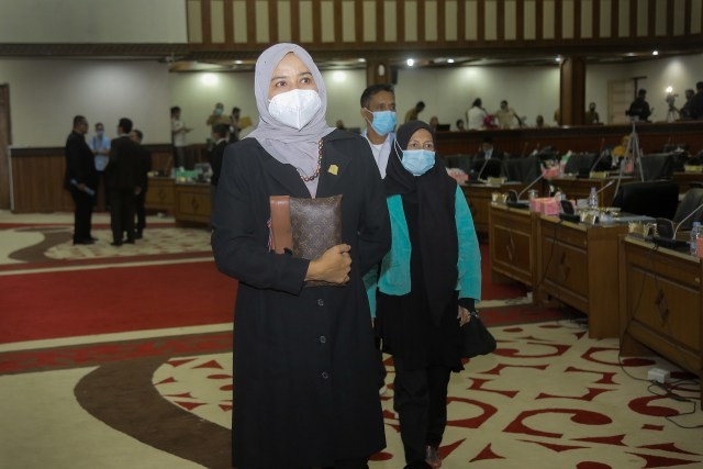 Darwati A Gani, anggota DPR Aceh terlihat memakai masker saat memasuki ruang sidang paripurna pada Selasa (27/10/2022). Foto: Abdul Hadi/acehkini