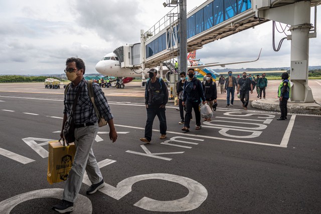 Sejumlah penumpang asal penerbangan Jakarta berjalan di area landasan parkir pesawat seusai tiba di Bandara Internasional Jenderal Ahmad Yani Semarang, Jawa Tengah, Selasa (26/4/2022). Foto: Aji Styawan/ANTARA FOTO