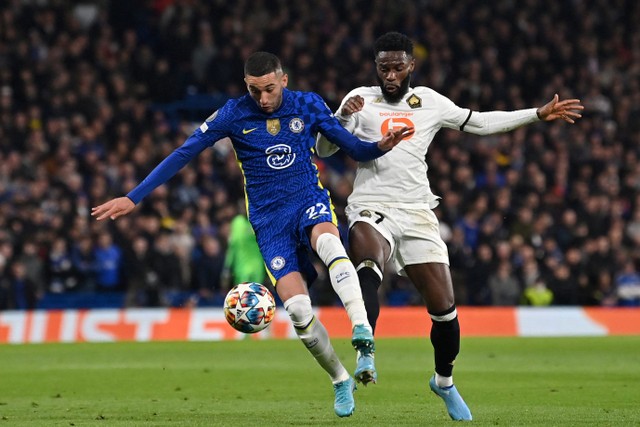 Pemain Chelsea Hakim Ziyech duel dengan pemain Lille Jonathan Bamba pada pertandingan leg pertama babak 16 besar Liga Champions UEFA di stadion Stamford Bridge, London. Foto: Glyn KIRK / IKIMAGES / AFP