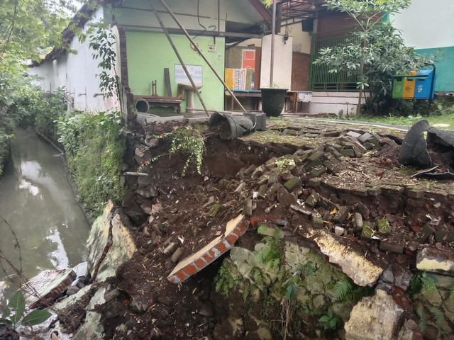 Kondisi tembok SMPN 11 Kota Malang yang ambrol tergerus aliran sungai. Foto: M Sholeh