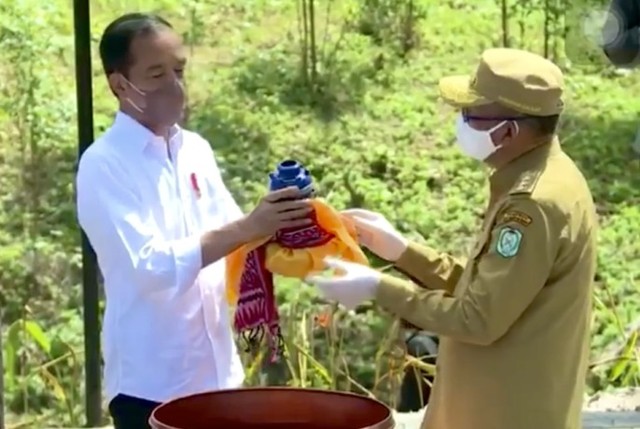 Gubernur Kalbar, Sutarmidji, saat menyerahkan air kapuas dan tanah dari garis equator kepada Presiden Jokowi. Air dan tanah itu akan dijadikan pondasi pembangunan IKN Nusantara. Foto: Biro Pers Set Presiden