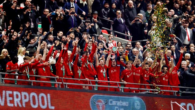 Pemain Liverpool berselebrasi dengan piala setelah memenangkan Piala Carabao di Stadion Wembley, London, Inggris, Minggu (27/2/2022). Foto: David Klein/REUTERS