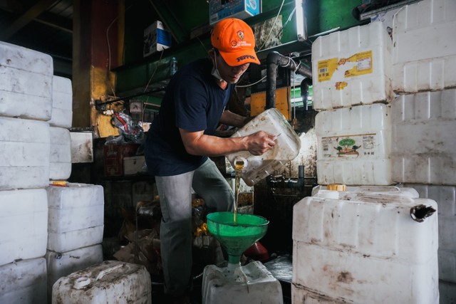 Penjual memasukan minyak goreng curah kedalam jirigen di Kawasan Pasar Cipete, Jakarta Selatan, Kamis (17/3/2022). Foto: Jamal Ramadhan/kumparan