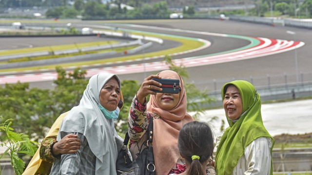 Sejumlah warga menonton sesi tes pramusim MotoGP 2022 dari atas bukit sekitar Pertamina Mandalika International Street Circuit di KEK Mandalika, Desa Kuta, Kecamatan Pujut, Praya, Lombok Tengah, NTB, Sabtu (12/2/2022). Foto: ANTARA FOTO/Ahmad Subaidi