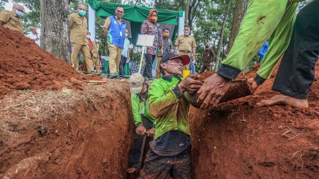Petugas Tempat Pemakaman Umum (TPU) mengikuti lomba gali kubur di TPU Pondok Rajeg, Kabupaten Bogor, Jawa Barat, Selasa (29/3/2022). Foto: Yulius Satria Wijaya/ANTARA FOTO