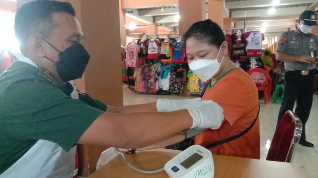 Petugas kesehatan Kodim 0735/Solo memberikan vaksinasi di Pasar Klewer. FOTO: Agung Santoso 