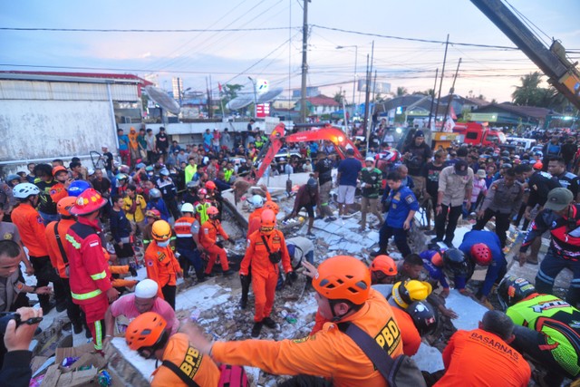 Tim SAR mengevakuasi korban yang terjebak di reruntuhan gedung retail modern Alfamart di Gambut Km 15, Kabupaten Banjar, Kalimantan Selatan, Senin (7/1/2021).  Foto: Iman Satria/ANTARA FOTO
