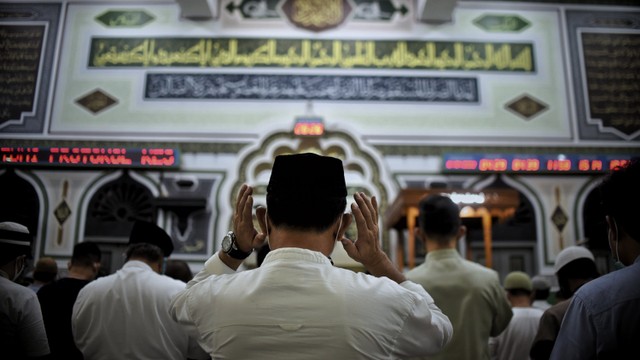 Seorang pria melakukan gerakan awal salat saat salat tarawih di Masjid Al-Azhar, Jakarta, Jumat (1/4/2022). Foto: Jamal Ramadhan/kumparan