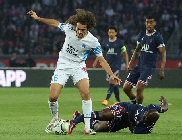 Paris Saint-Germain (PSG) player Danilo Pereira fights for the ball with Marseille's players during the French League continuation match at the Parc des Princes, Paris, France.  Photo: Sarah Meyssonnier/REUTERS