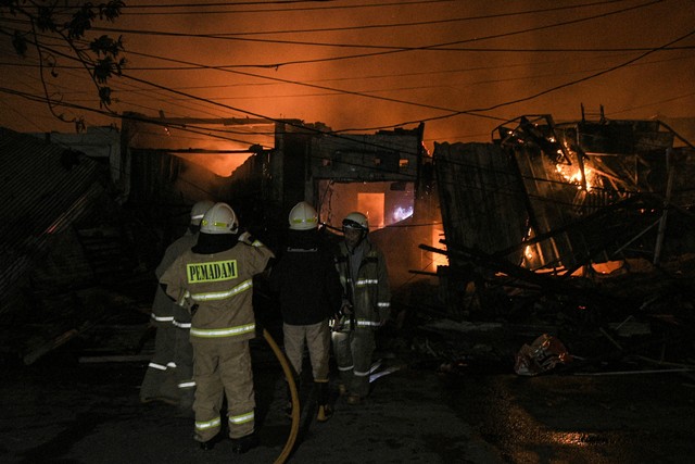 Sejumlah pemadam kebakaran memadamkan api yang membakar kios dan rumah di pasar Gembrong, Jatinegara, Jakarta Timur, Minggu (24/4/2022). Foto: Fakhri Hermansyah/ANTARA FOTO