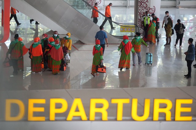 Calon jamaah umrah berjalan di Terminal 2 Bandara Internasional Juanda Surabaya di Sidoarjo, Jawa Timur, Senin (14/3/2022).  Foto: Umarul Faruq/ANTARA FOTO