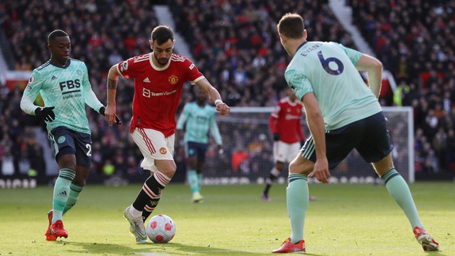 Pemain Manchester United Bruno Fernandes beraksi dengan pemain Leicester City Nampalys Mendy dan Jonny Evans di Stadion Old Trafford, Manchester, Inggris, Sabtu (2/4/2022). Foto: Russell Cheyne/REUTERS