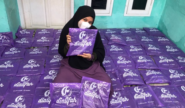 Potret Fadilla Alifah, Owner produsen gamis Bekasi Dialifah memegang produk gamis yang sudah di-packing