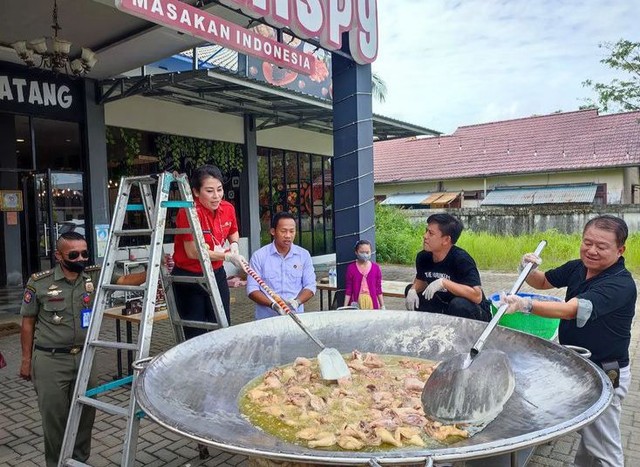 Wali Kota Singkawang, Tjhai Chui Mie bersama petinju Daud Cino Yordan menggoreng ayam di kuali ukuran besar. Foto: Instagra, @tjhaichuimie