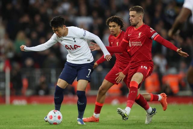 Pemain Liverpool Jordan Henderson and Trent Alexander-Arnold berebut bola dengan pemain Tottenham Hotspur Son Heung-min pada pertandingan lanjutan Liga Inggris di Anfield, Liverpool, Inggris. Foto: Phil Noble/REUTERS