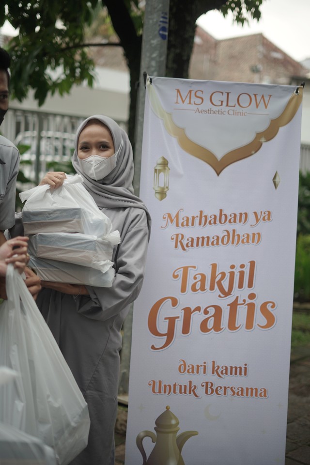 Karyawan MS Glow, bagian dari J99 Corp membagikan paket buka puasa kepada masyarakat dan pengguna jalan. Foto: J99 Corp