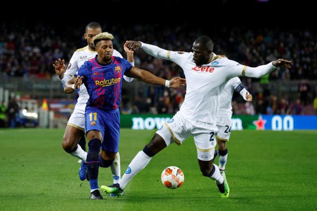 Pemain FC Barcelona Adama Traore berebut bola dengan pemain Napoli Kalidou Koulibaly pada pertandingan play off 16 besar Liga Europa di Camp Nou, Barcelona, Spanyol. Foto: Albert Gea/REUTERS