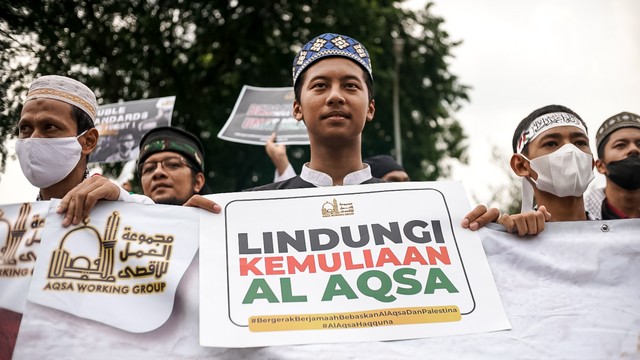 Lembaga kemanusiaan Aqsa Working Group (AWG) membawa poster bertuliskan lindungi kemuliaan Al Aqsa saat Aksi Bela Al-Aqsa di Jalan Medan Merdeka Selatan, Jakarta pada Rabu (20/4/2022). Foto: Iqbal Firdaus/kumparan