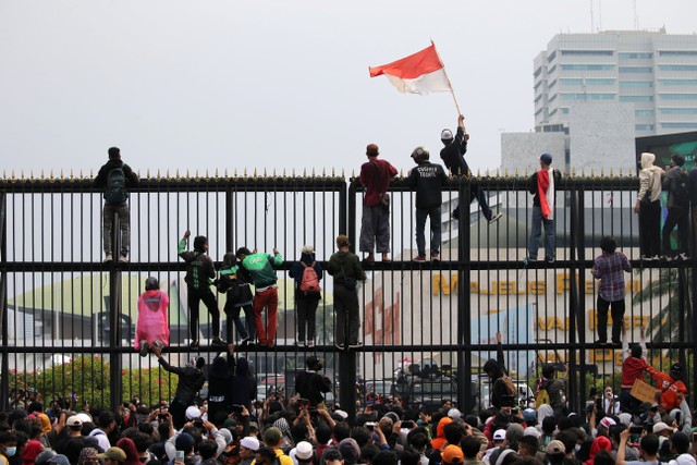 Siswa STM memanjat pagar DPR saat Aliansi Badan Eksekutif Seluruh Indonesia (BEM SI) menggelar aksi demo 11 April di depan Gedung DPR RI, Jakarta, Senin (11/4/2022). Foto: Aditia Noviansyah/kumparan