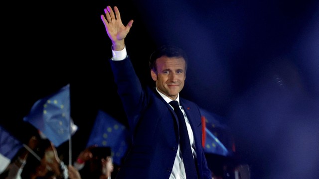 Presiden Prancis Emmanuel Macron melambai di atas panggung, setelah terpilih kembali sebagai presiden, selama reli kemenangannya di Champ de Mars di Paris, Prancis, Minggu (24/4/2022). Foto: Christian Hartmann/REUTERS