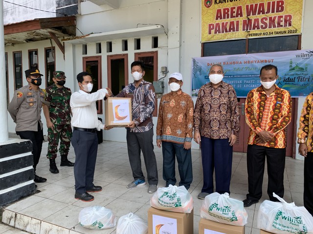 Head Unit PT SAP Kumai, Husni Effendi secara simbolis menyerahkan paket sembako kepada Lurah Kumai Hulu. Joko Hardyono/InfoPBUN