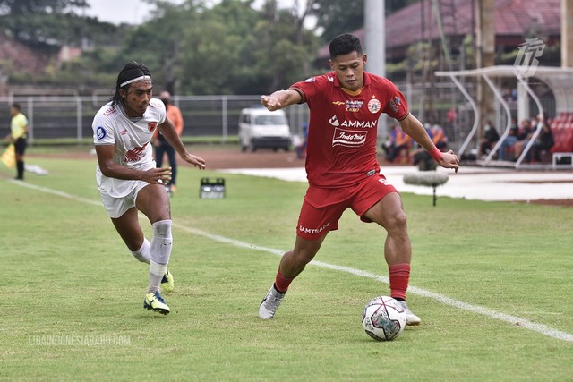 Erwin Gutawa berduel dengan Osvaldo Haay dalam laga Persija vs PSM dalam laga pekan ke-32 Liga 1 2021/22 di Stadion Gelora Ngurah Rai, Bali, pada Senin (21/3/2022) Foto: Situs web resmi Liga Indonesia Baru