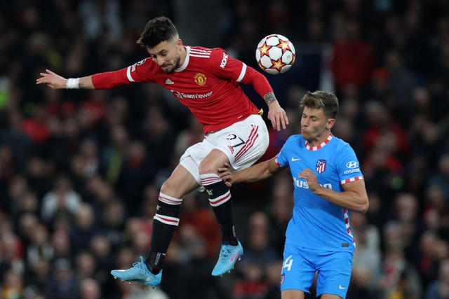 Pemain Manchester United Alex Telles berebut bola dengan pemain Atletico Madrid Marcos Llorente pada pertandingan leg kedua babak 16 besar Liga Champions di ld Trafford, Manchester, Inggris. Foto: Phil Noble/REUTERS