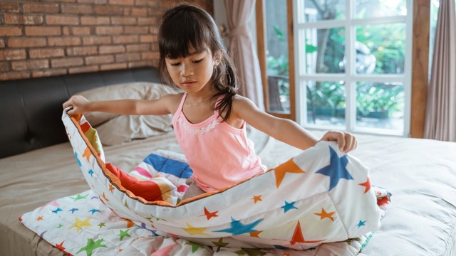 Ilustrasi anak merapikan tempat tidur. Foto: Odua Images/Shutterstock